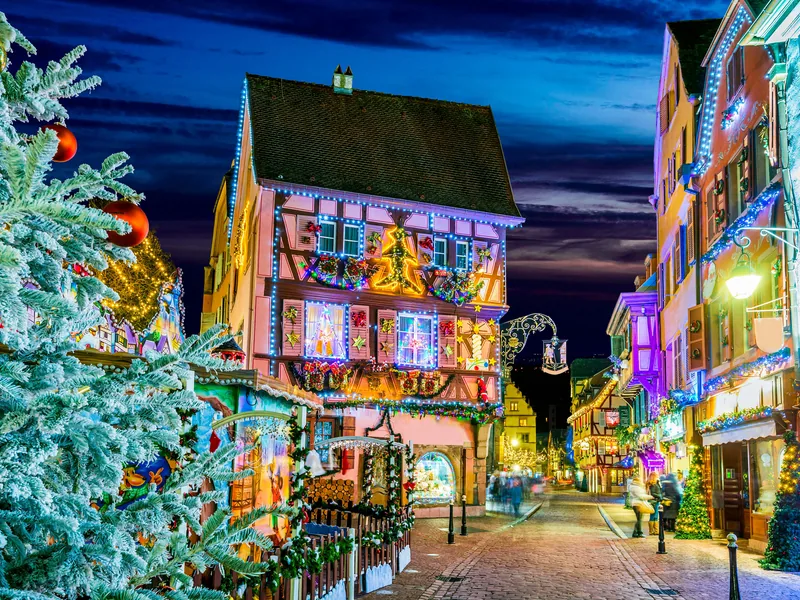Colmar Christmas market at night with illuminated chalets and a decorated tree